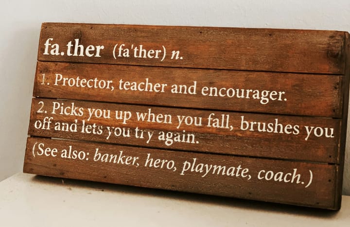A wooden sign board with a written meaning of "father"